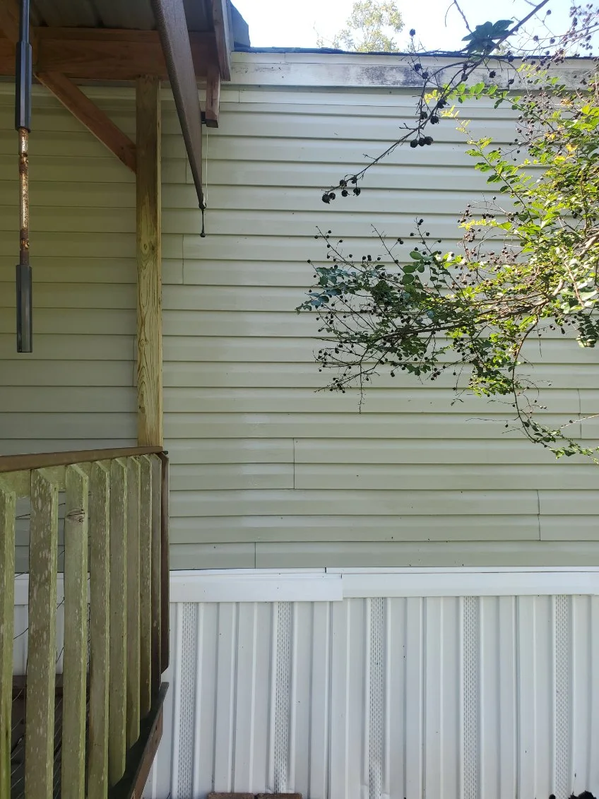 A clean wood rail beside washed siding